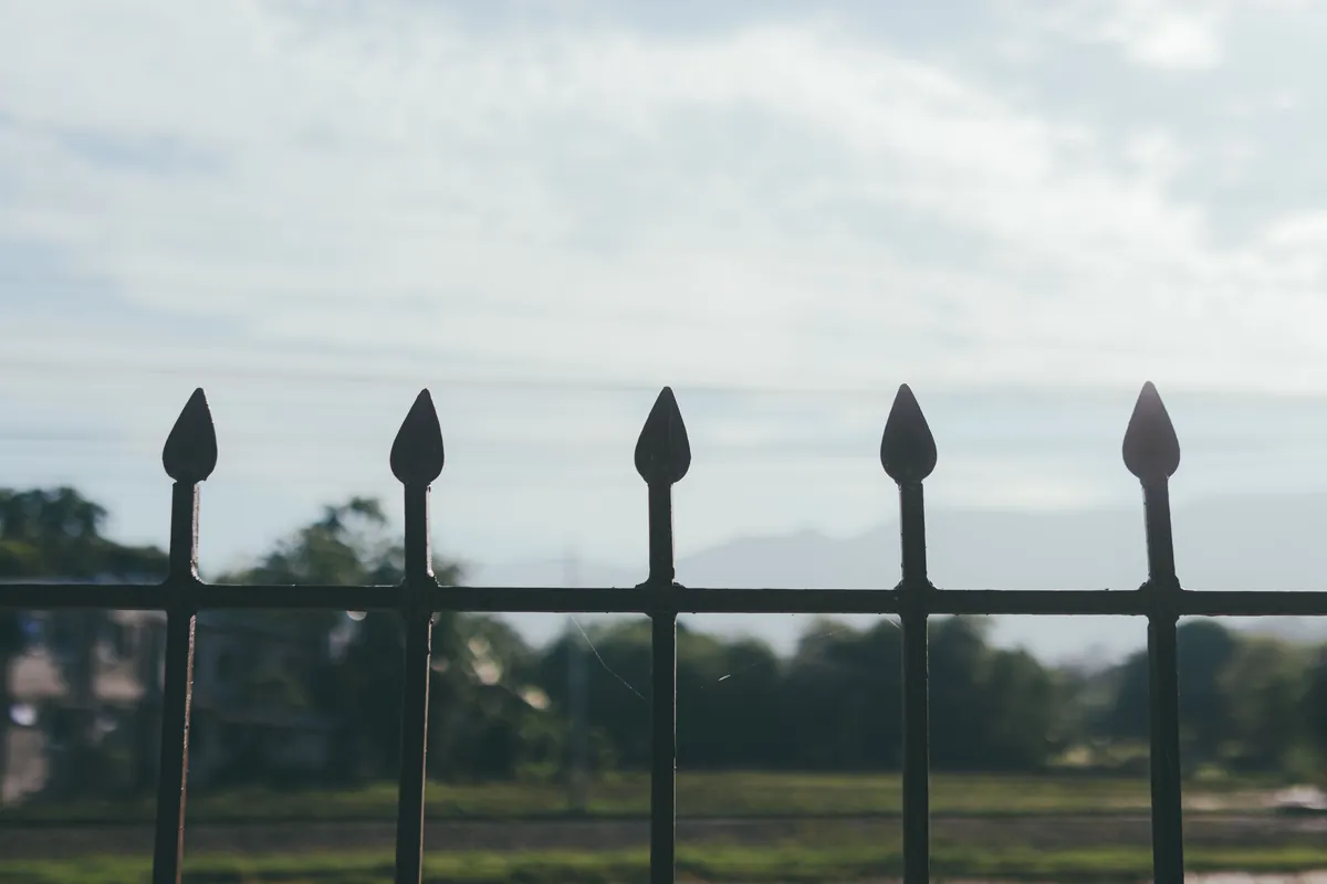 Black ornamental metal fence with spear-point pickets